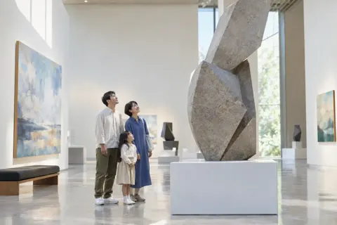 親子で彫刻を見上げる様子（美術館・ギャラリー・展示の写真 No.27）