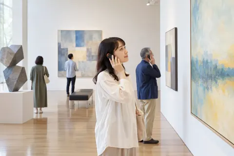 音声ガイドを耳に当てて作品を見る来館者（美術館・ギャラリー・展示の写真 No.30）