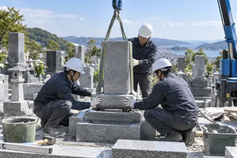 墓地で墓石をすえつける石工たち（仏壇・墓石・供養の写真 No.30）