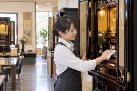 仏壇の中をふいて手入れをする店員（仏壇・墓石・供養の写真 No.42）