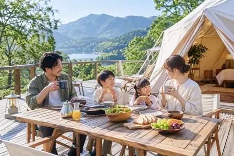 グランピングのデッキで朝食を食べる家族（キャンプ場・グランピングの写真 No.19）