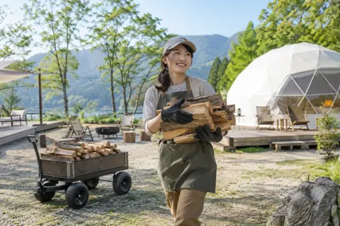 まきを運ぶスタッフ（キャンプ場・グランピングの写真 No.21）