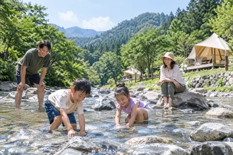 川で遊ぶ子どもたちと見守る親（キャンプ場・グランピングの写真 No.23）