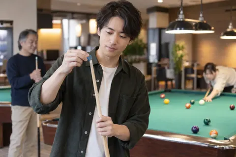 キューの先にチョークをつける人（ゲームセンター・ボウリング・ビリヤードの写真 No.20）