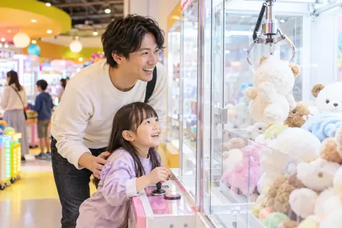 クレーンゲームで景品をねらう親子（ゲームセンター・ボウリング・ビリヤードの写真 No.21）