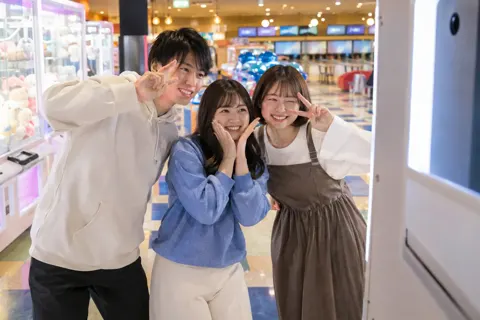 写真を撮る機械の前でポーズをとる友だちどうし（ゲームセンター・ボウリング・ビリヤードの写真 No.29）