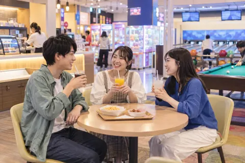 軽食のコーナーで飲み物を飲む友だちどうし（ゲームセンター・ボウリング・ビリヤードの写真 No.34）