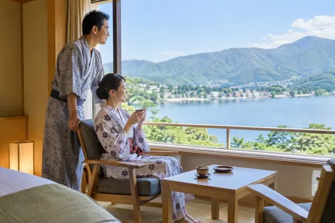 浴衣で部屋の窓から景色を見る夫婦（ホテル・旅館の写真 No.33）