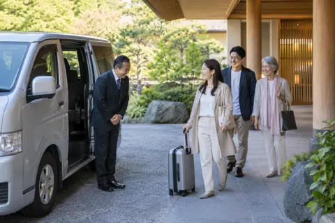 送迎の車の前でお客様を迎える運転手（ホテル・旅館の写真 No.44）