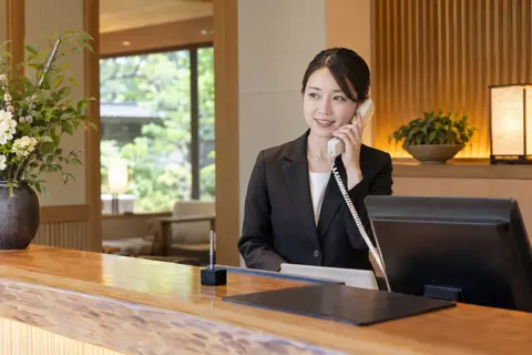 フロントで電話を受けるスタッフ（ホテル・旅館の写真 No.46）