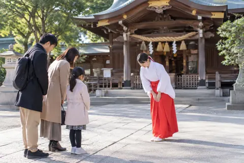 お参りの人におじぎをする巫女（神社・寺院・教会の写真 No.26）