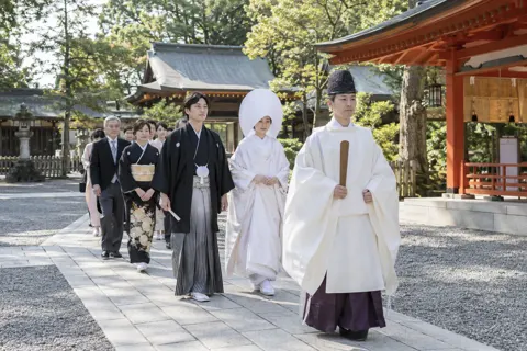 神前の結婚式で進む新郎新婦と神職（神社・寺院・教会の写真 No.33）