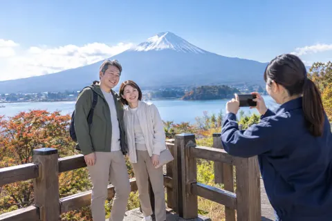 記念の写真を撮ってもらう夫婦とスタッフ（観光・体験・道の駅の写真 No.43）
