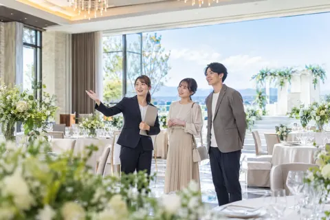 会場を見学する二人とプランナー（結婚式場・ウェディングの写真 No.26）
