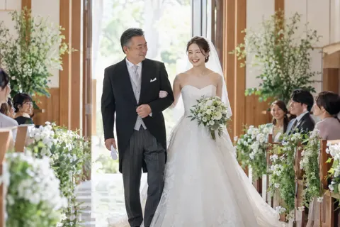 父親と腕を組んで歩く新婦（結婚式場・ウェディングの写真 No.32）