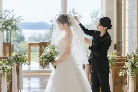 新婦のベールを直す介添えのスタッフ（結婚式場・ウェディングの写真 No.41）