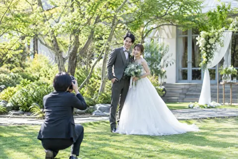 庭で写真を撮ってもらう新郎新婦（結婚式場・ウェディングの写真 No.44）