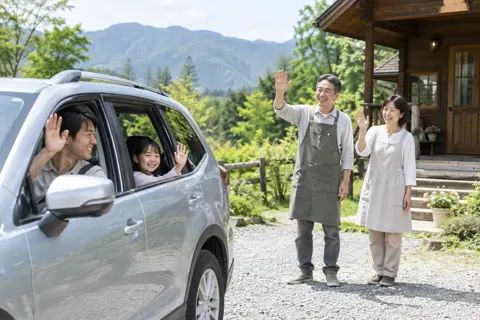 出発するお客様を見送るオーナーの夫婦（ペンション・コテージの写真 No.35）