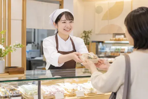 売り場でお客様に商品をわたす店員（食品製造・販売の写真 No.44）