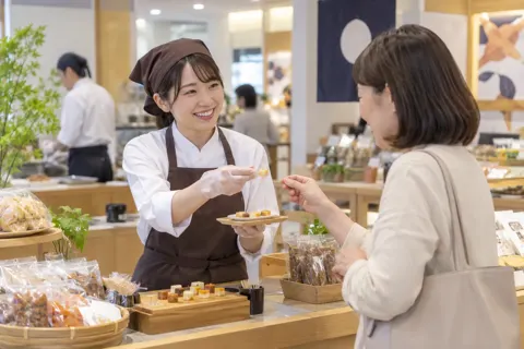 試食をすすめる店員とお客様（食品製造・販売の写真 No.45）