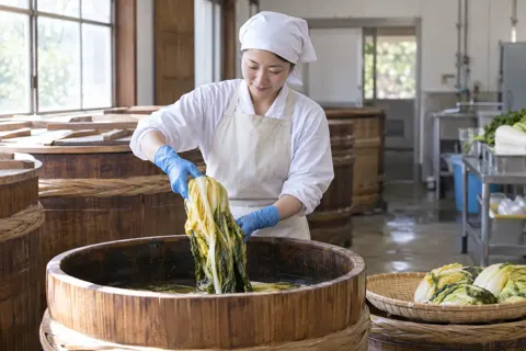 つけものをたるからあげる作り手（食品製造・販売の写真 No.53）