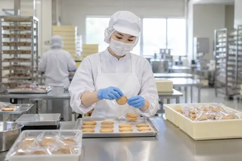 菓子を1つずつふくろに入れる作り手（食品製造・販売の写真 No.59）