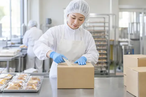 シールで箱をとじる作り手（食品製造・販売の写真 No.62）