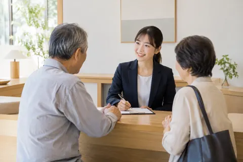 カウンターでお客様の話を聞くスタッフ（その他（上記にない業種）の写真 No.27）
