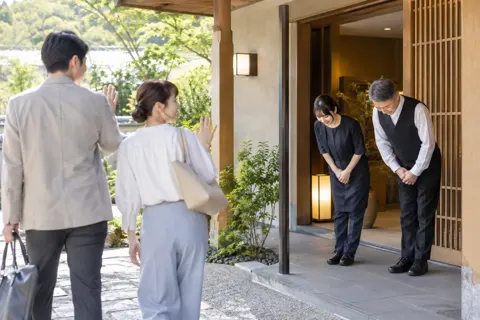お客様を外まで見送っておじぎをするスタッフ（その他（上記にない業種）の写真 No.48）