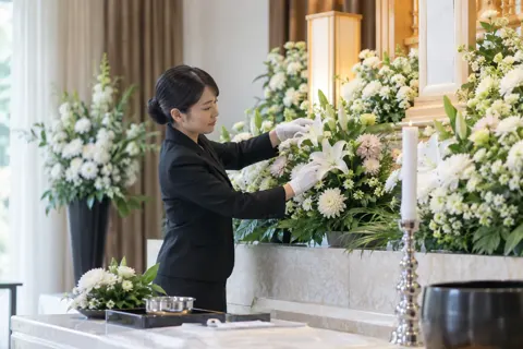 祭壇の花を整えるスタッフ（葬儀・葬祭・斎場の写真 No.27）