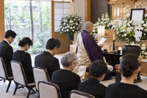 お経を読むお坊さんと参列の人たち（葬儀・葬祭・斎場の写真 No.33）