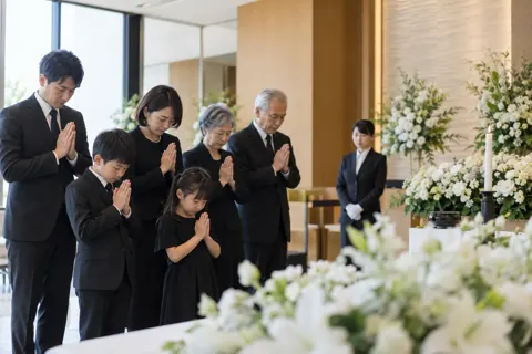 手を合わせるご家族（葬儀・葬祭・斎場の写真 No.34）