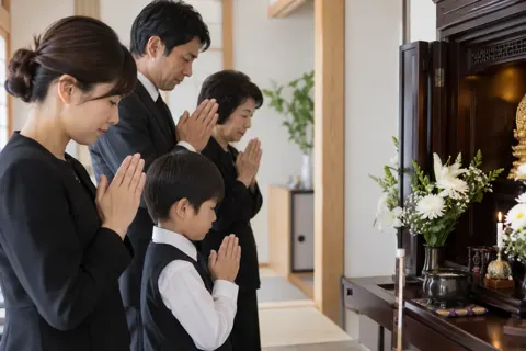 仏壇の前で手を合わせる家族（葬儀・葬祭・斎場の写真 No.42）