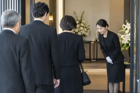 玄関で参列の人を迎えるスタッフ（葬儀・葬祭・斎場の写真 No.47）