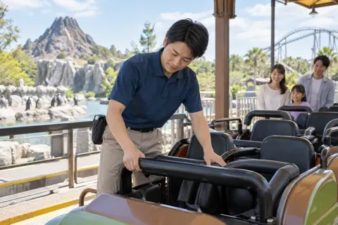 乗り物の安全バーを確かめるスタッフ（水族館・動物園・テーマパークの写真 No.31）