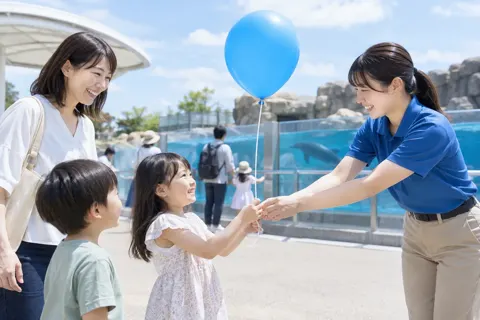 風船を子どもに渡すスタッフ（水族館・動物園・テーマパークの写真 No.32）