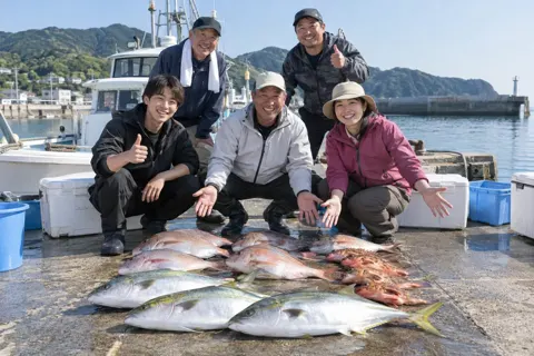 釣った魚をならべて記念の写真を撮るお客様たち（釣り船・遊漁船の写真 No.30）