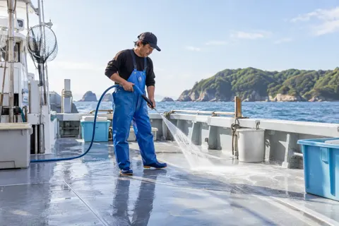 船の甲板を水で洗う船長（釣り船・遊漁船の写真 No.31）