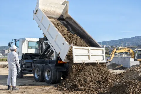 ダンプカーの荷台を上げて土を下ろす（運送・配送・トラックの写真 No.55）