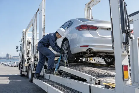 車を運ぶ専用のトラックに車をのせるドライバー（運送・配送・トラックの写真 No.57）