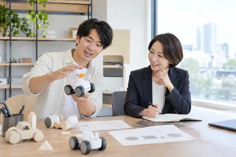 おもちゃの試作品を動かして見せる開発者と弁理士（弁理士・特許の写真 No.20）