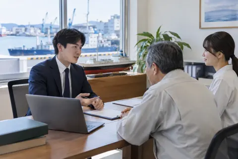 船の模型が置かれた相談室での打ち合わせ（海事代理士の写真 No.19）