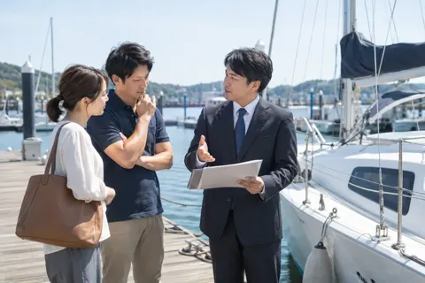 ヨットの持ち主に手続きの流れを説明する海事代理士（海事代理士の写真 No.20）