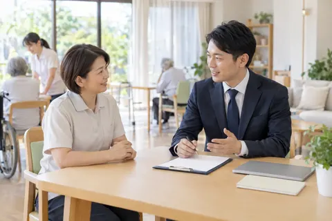 介護の事業所で所長と話す社労士（司法書士・社労士の写真 No.19）