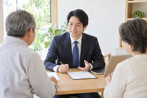 無料の相談会で机をはさんで話を聞く司法書士（司法書士・社労士の写真 No.23）