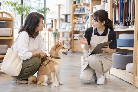 しつけの相談を受ける店員と飼い主（ペット用品店の写真 No.33）