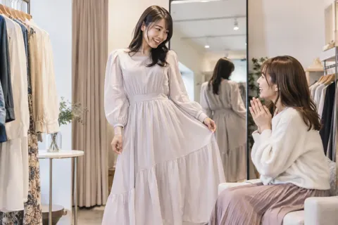 試着した服を友だちに見せるお客様（ファッション・アパレル・靴の写真 No.28）