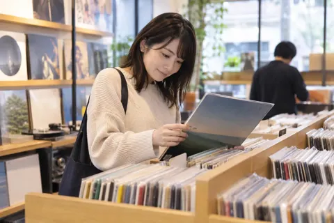 レコードを棚から選ぶお客様（楽器店・レコードの写真 No.25）