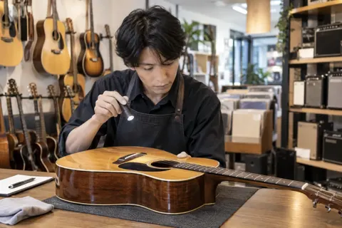 中古の楽器を買い取るために調べる店員（楽器店・レコードの写真 No.28）