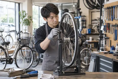 車輪のゆがみを直す店員（自転車販売・修理の写真 No.33）